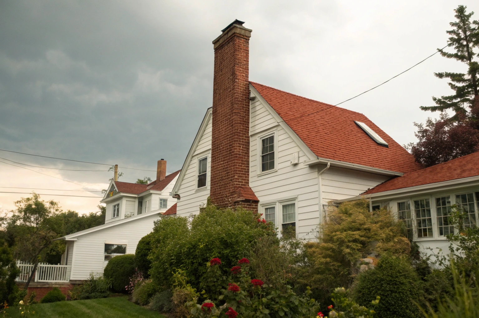 Traditional white house with prominent brick chimney and fireplace New York residential architecture featuring red tile roof