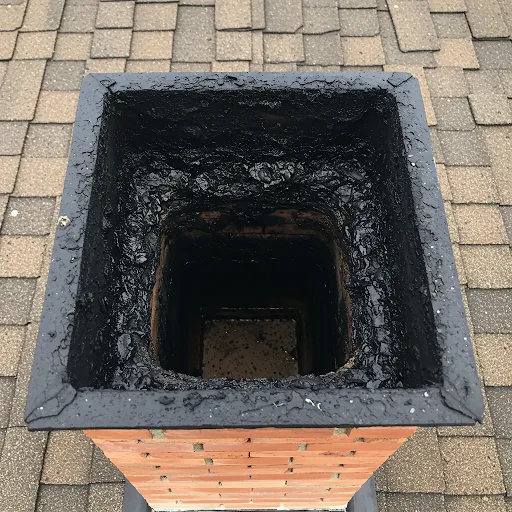 Dangerous level of black creosote buildup inside residential chimney flue requiring professional chimney sweeping
